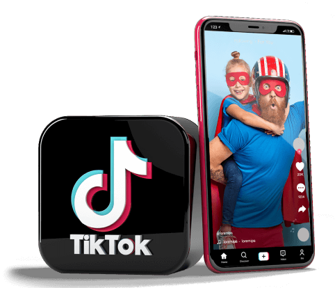 Smartphone apoiado em um totem com a logo do tiktok. Na tela do celular passa um video de um pai brincando de super herói com sua filha pequena nas costas.