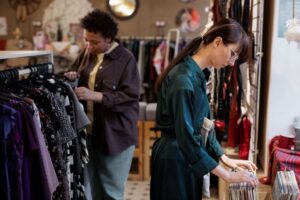 Duas mulheres em uma loja com roupas e discos.