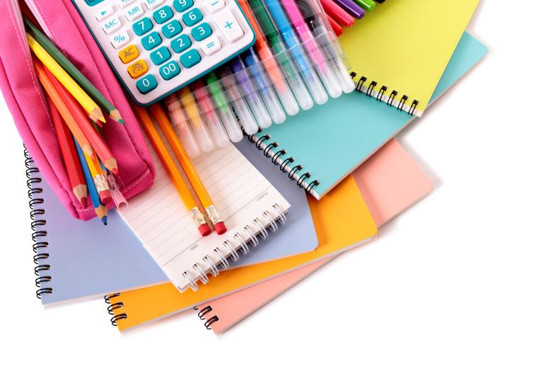 Materiais escolares coloridos sobre uma mesa.