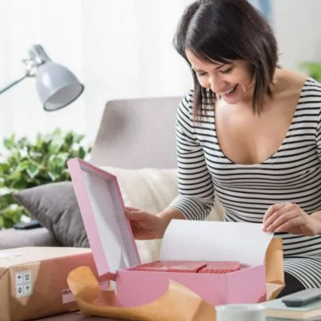 a imagem mostra uma mulher abrindo uma caixa. Provavelmente ela está fazendo unboxing de algum produto