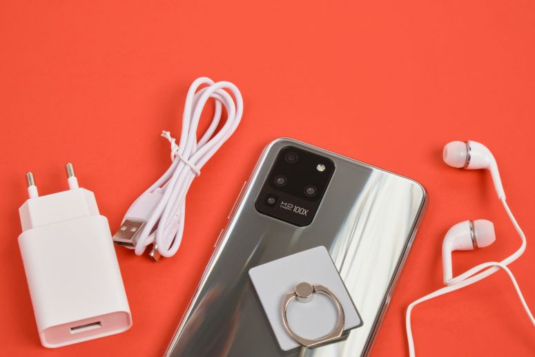 A imagem mostra acessórios para celular sob fundo laranja.