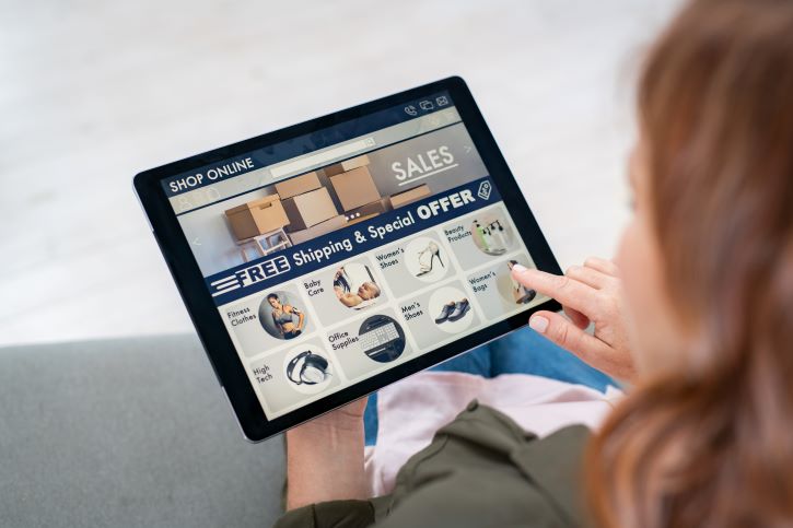 a imagem mostra uma mulher com um tablet nas mãos, acessando uma loja online.