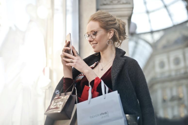 Mulher feliz com compras no celular
