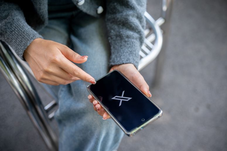 Mulher abrindo o X no celular 