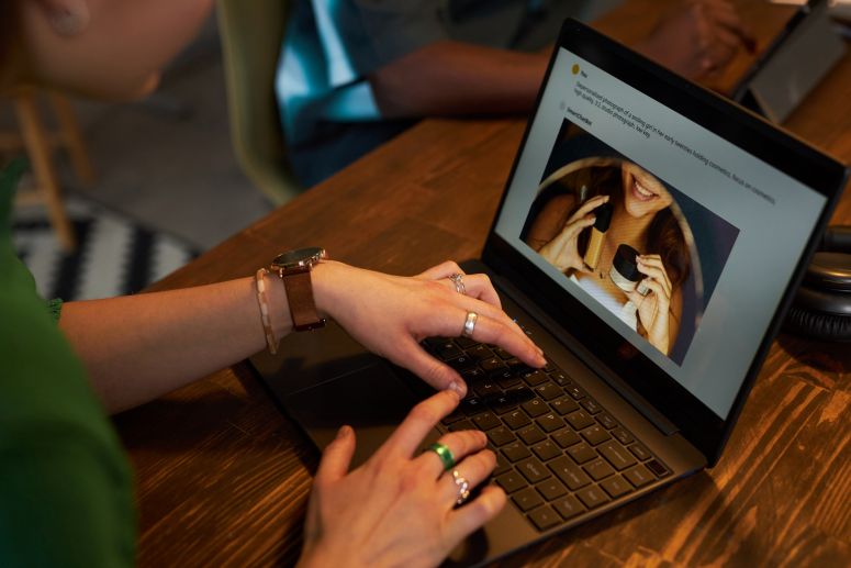 Mulher com notebook aberto acessando uma página na internet.