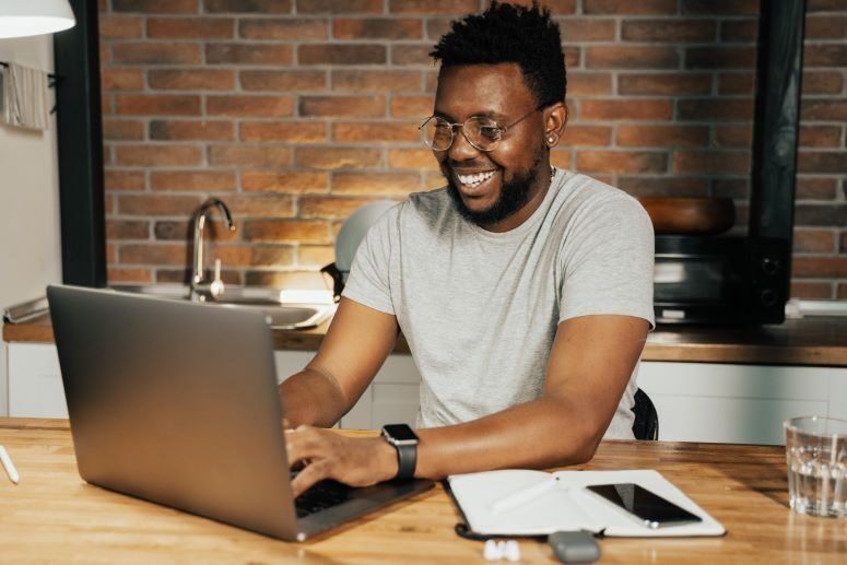 Franquia online: rapaz sorrindo enquanto usa o computador