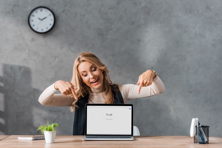 a imagem mostra uma mulher apontando para um notebook logado no Google. Ela está configurando o Google alerts para ser informada sobre as novidades de assuntos do seu interesse.