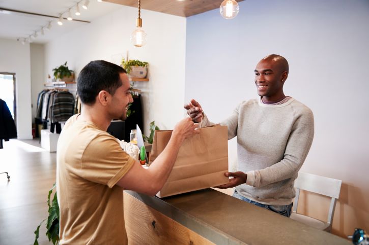 a imagem mostra um homem devolvendo um produto comprado na loja física