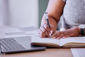 a imagem mostra mulher com notebook e laptop fazendo uma ordem de compra