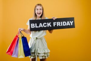 Moça com sacolas de compras e uma placa escrita Black Friday