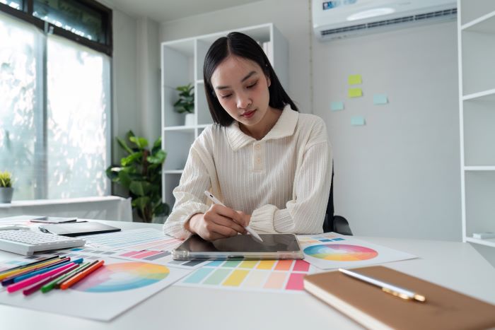a imagem mostra uma mulher designer gráfica de uma empresa, trabalhando no marketing visual da loja