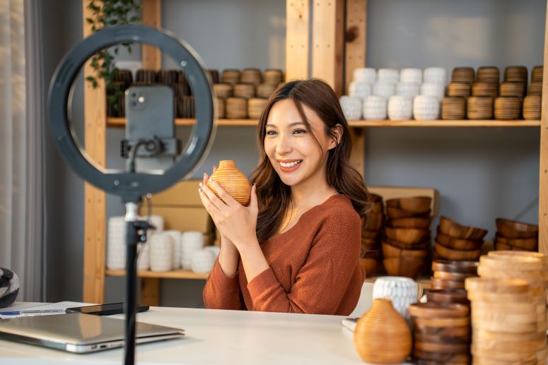 a imagem mostra uma mulher branca realizando uma live shop na sua loja