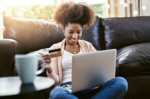 a imagem mostra uma mulher negra comprando pela internet. Com certeza ela irá retirar a compra na loja física. Uma das estratégias associadas ao Unified Commerce