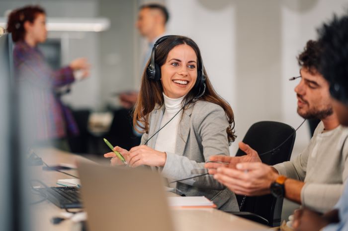 a imagem mostra Um operador de telemarketing está sentado no call center e recebendo uma ligação telefônica.