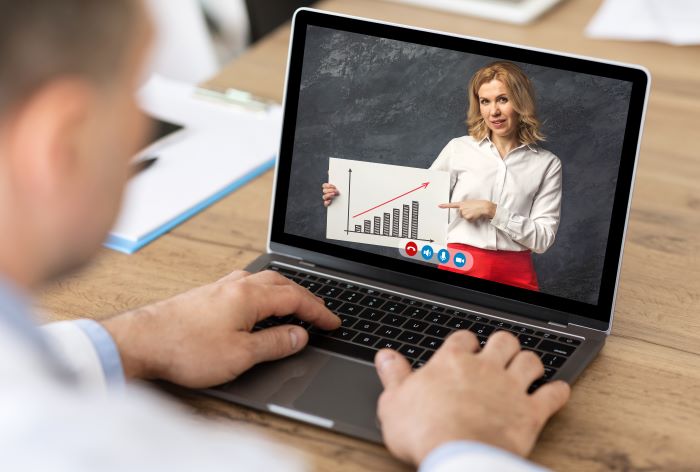 homem se reunindo com colega em videochamada via laptop. Eles estão buscando um curso sobre tráfego pago.