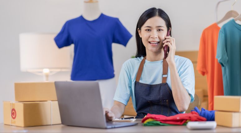Empreendedora atendendo cliente e organizando pedidos — exemplo prático de como vender camisetas personalizadas online.