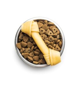 Comedouro com ração, escova para pelos e bola colorida para pets, representando itens básicos de um pet shop.