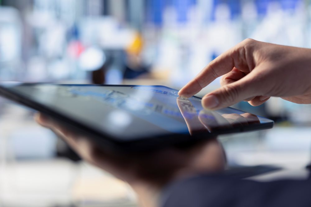 Pessoa utilizando um tablet para gerenciar operações de loja, representando a integração entre loja física e digital com uso de tecnologia.