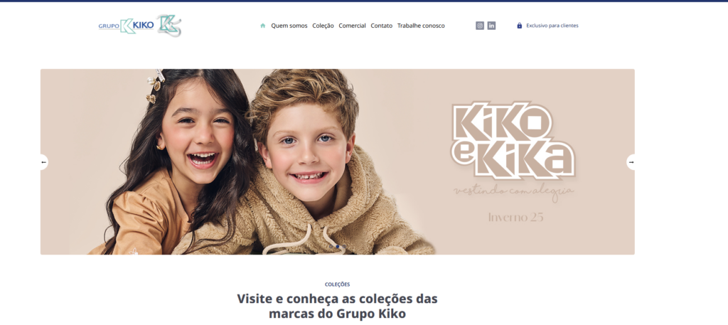 A imagem mostra duas crianças sorridentes. Uma menina morena e um menino loiro com roupas beges.