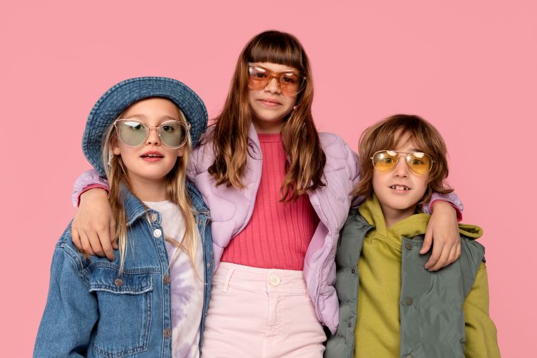 A imagem mostra a imagem de três crianças estilosas de idades diferentes.