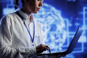 Mulher mexendo em um notebook dentro de uma operação tecnológica.