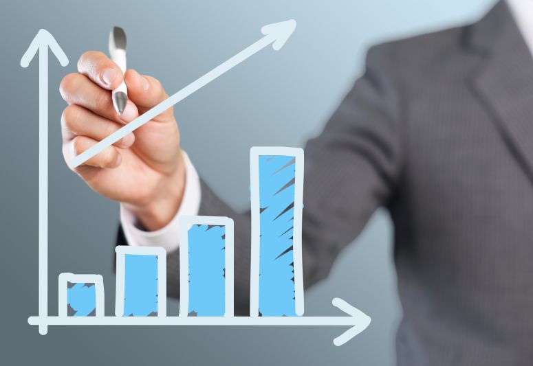 homem de terno desenhando gráfico positivo