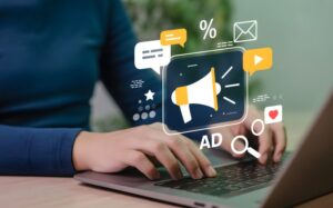 mãos digitando em um laptop com símbolos de ads
