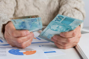 imagem de uma mão masculina contando dinheiro. Ilustração de como ganhar dinheiro em minutos