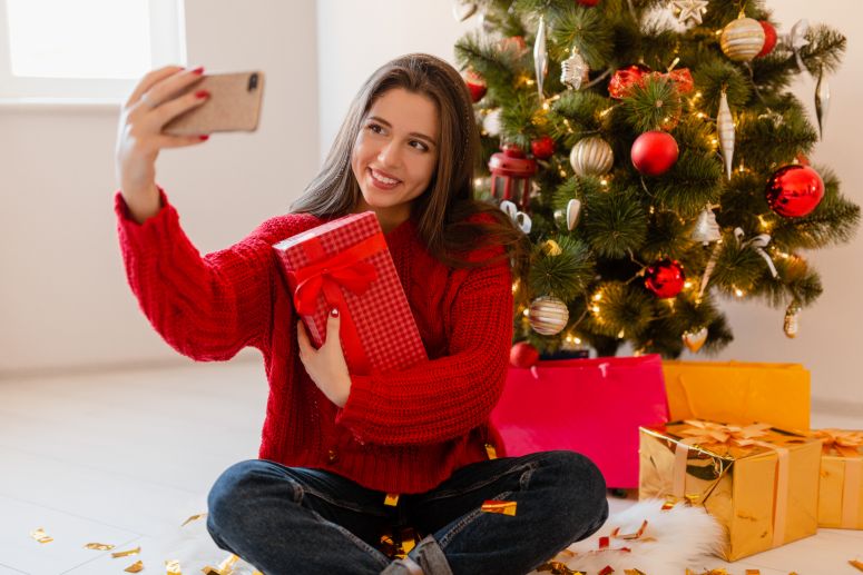 Garota fazendo selfie com seus presentes de natal.
