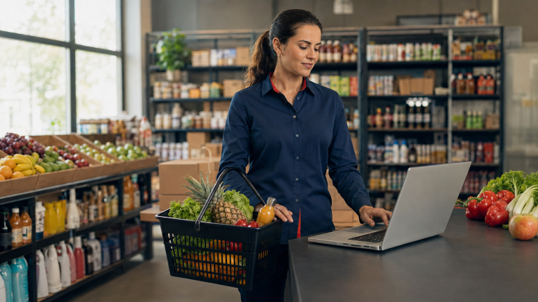Mulher com cesta de mercado em frente ao notebook